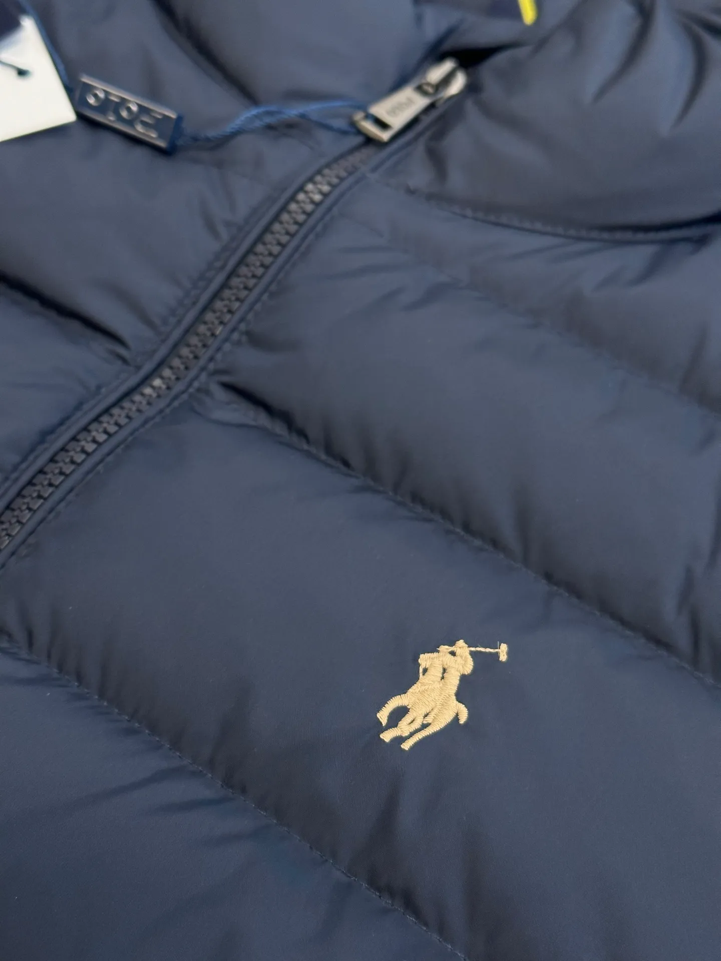 P890 Ralph Lauren lightweight down jacket. The nylon fabric has good windproof and waterproof properties, which can effectively block the intrusion of wind and rain from the outside and keep the inside dry. It is suitable for wearing in humid or rainy environments. The red label on the chest is made with an imported MECLO embroidery machine. The original pattern is scanned first, and then high-quality silk thread is used to make a pattern. The density effect is adjusted by continuous pattern making.  The zipper design is simple and elegant, easy to operate, and the closing design of the cuffs and hem effectively prevents cold wind from invading, improving the warmth and comfort of wearing. It uses 90 white duck down with a weight of 260g to ensure excellent thermal insulation performance. After strict screening and processing, the velvet is not easy to drill, ensuring durability. size: s m l xl